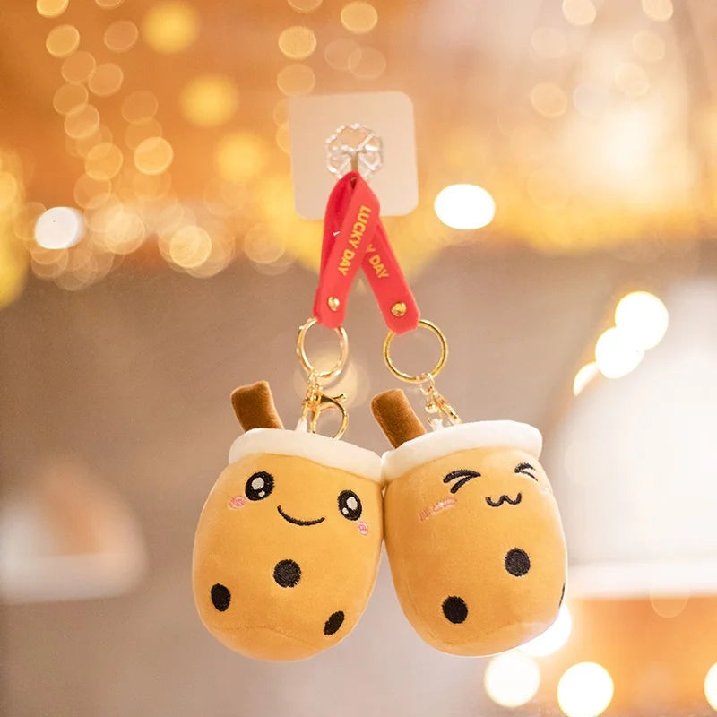 Plush keychains shaped like kawaii cartoon-style bubble tea with a blurred background