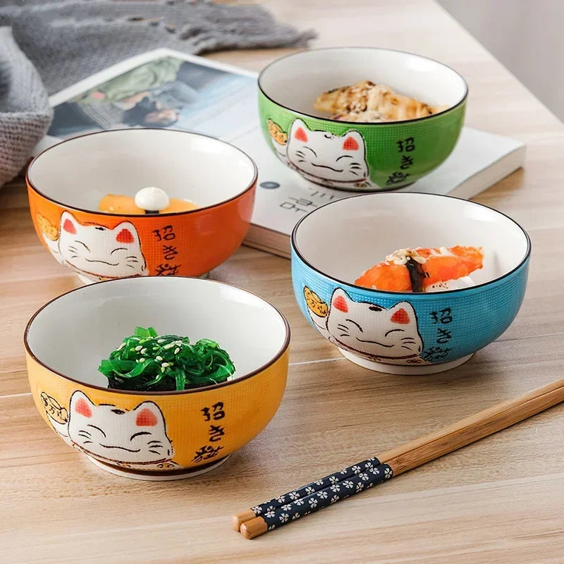 Four colorful kawaii ramen bowls with cat designs on a wooden table, each containing different food items.