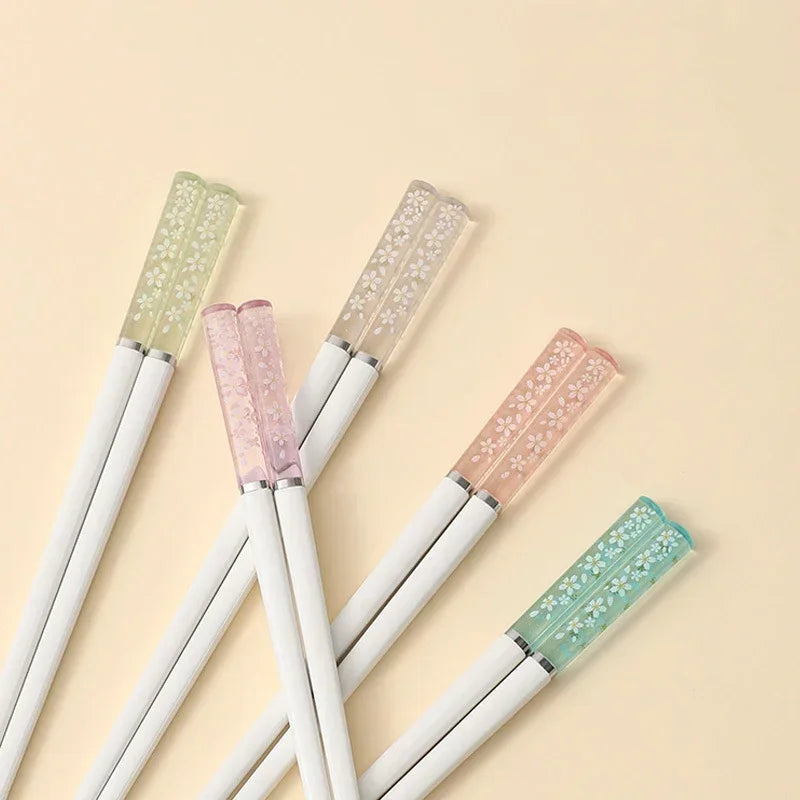 Set of kawaii chopsticks with decorative caps on a beige background