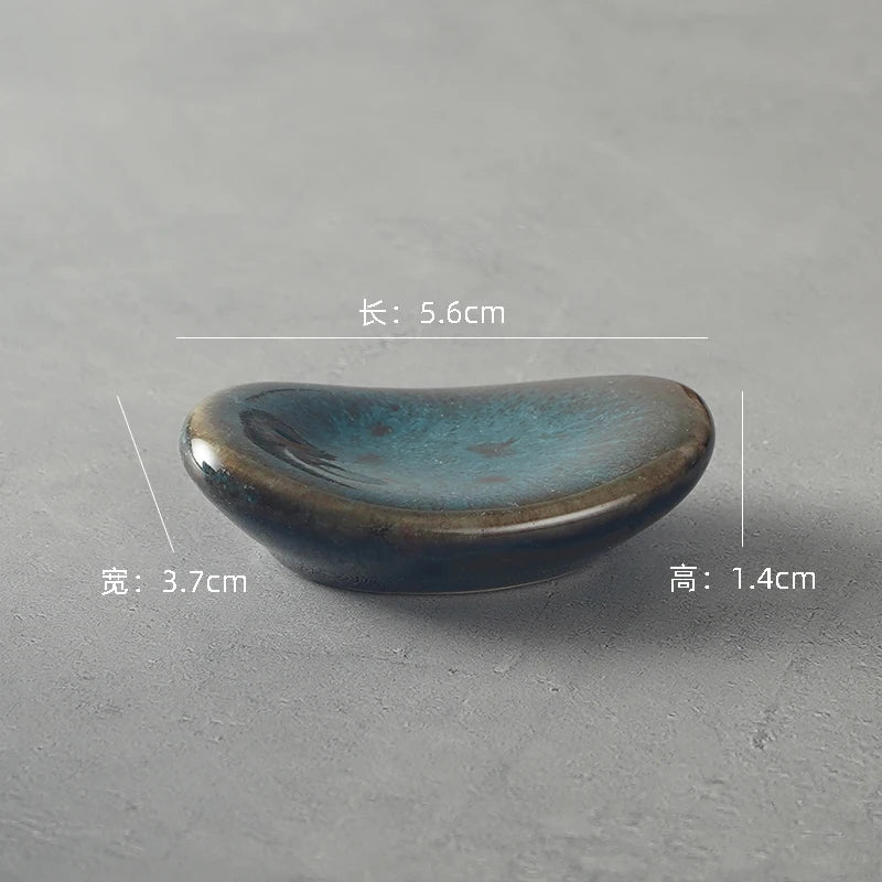A gray ceramic kawaii chopstick holder on a table
