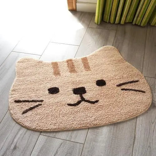 Cat-shaped kawaii doormat with a face design on a wooden floor.