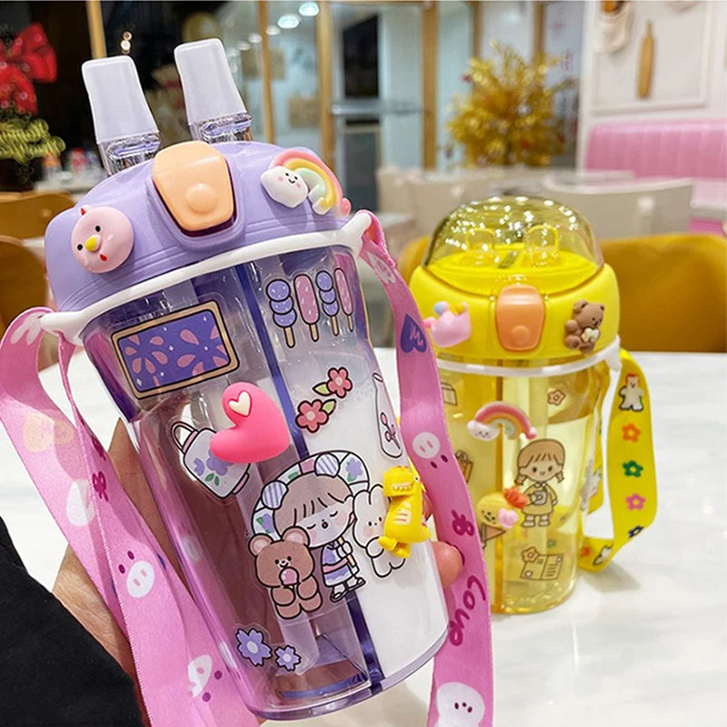 Two colorful children's kawaii water bottles with cartoon designs on a table.