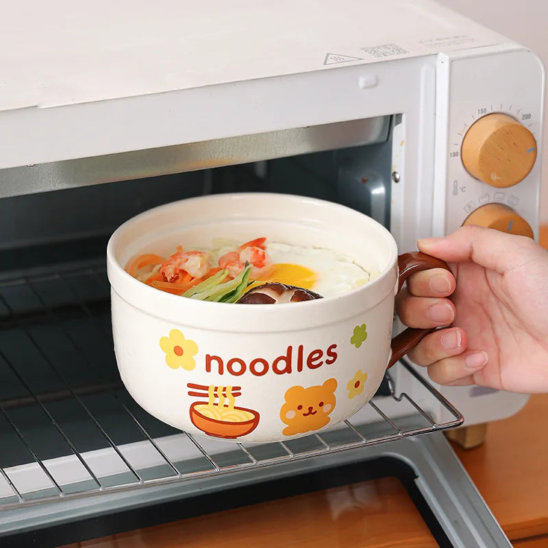 Person placing a cartoon-themed noodle kawaii ramen bowl into a microwave.