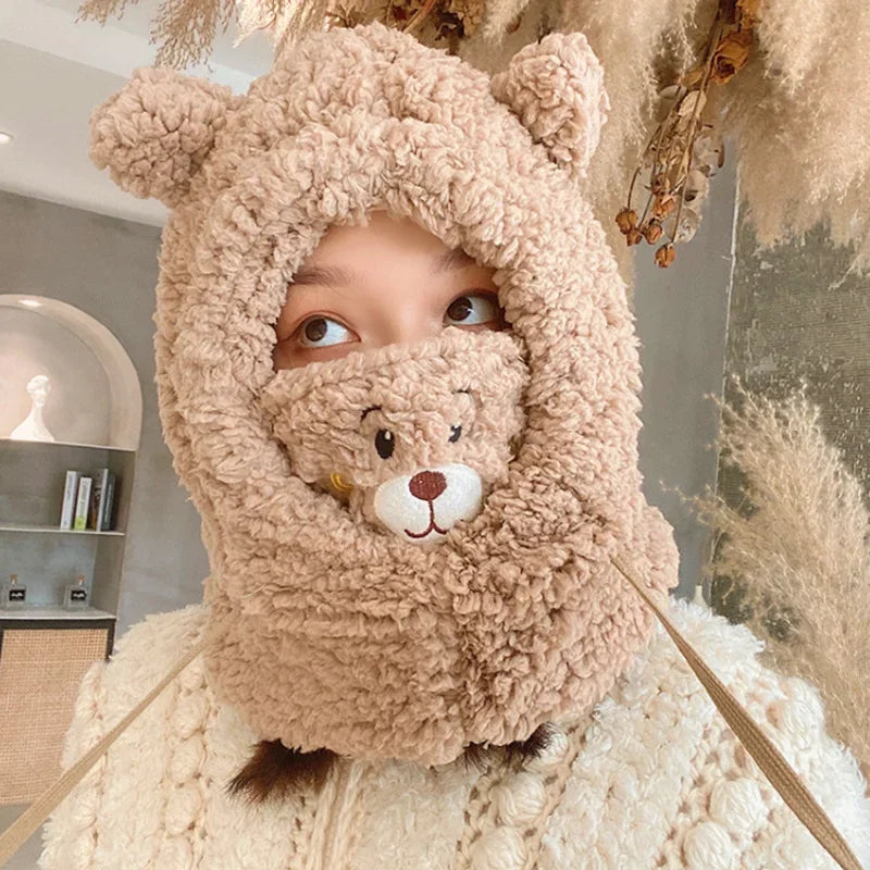 Person wearing a fluffy Kawaii beige bear costume with a hood in an indoor setting.