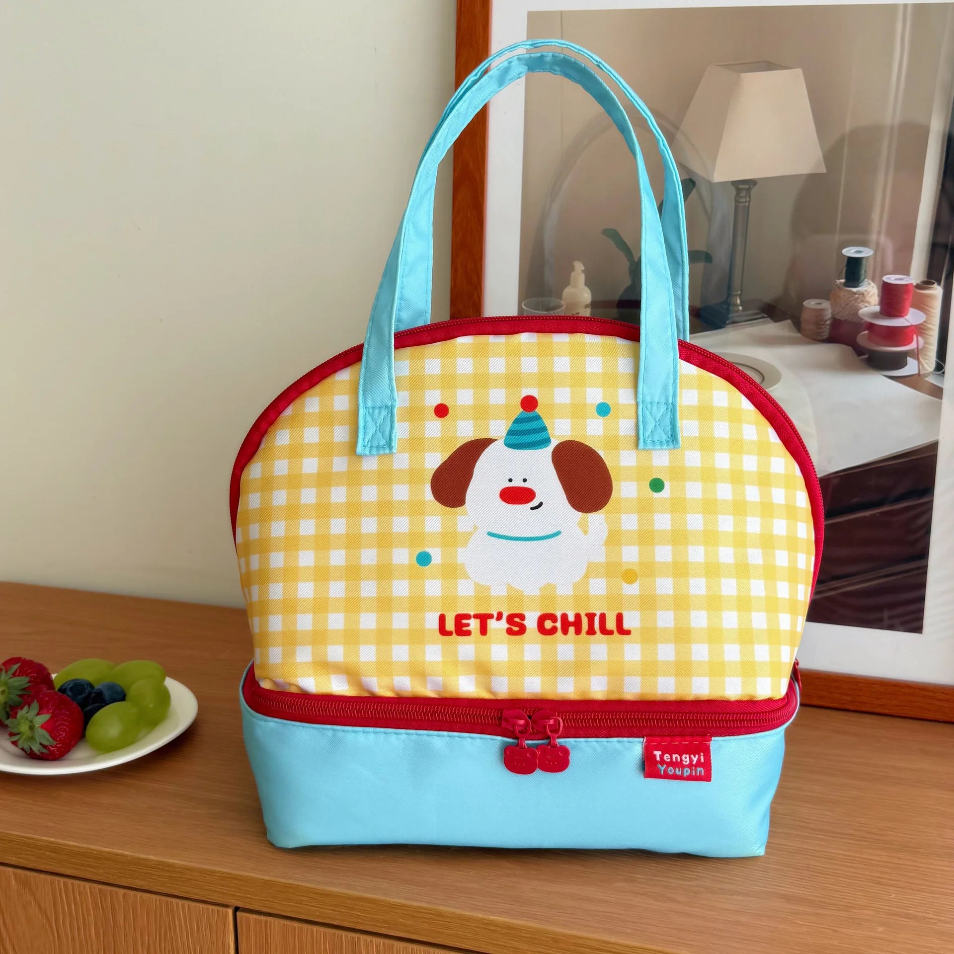 Yellow checkered kawaii lunch bag with a cartoon dog design on a wooden surface.