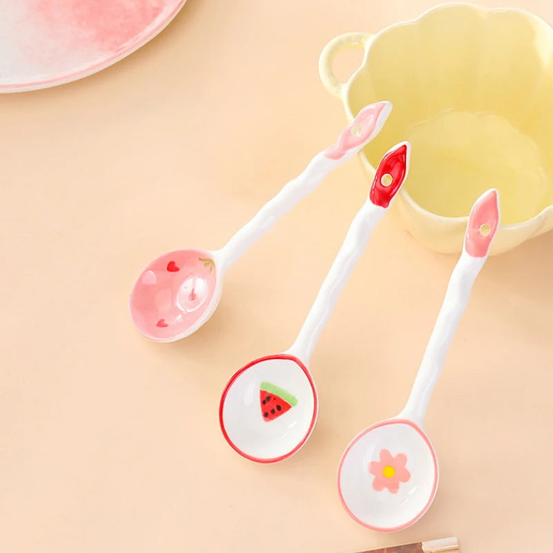 Three white and pink kawaii spoons sitting on a table