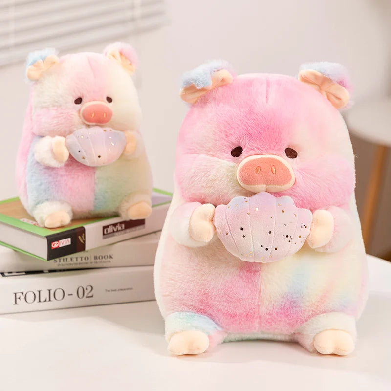 Two kawaii plush toys in a pig shape holding shells, one sitting on a book, one sitting on a table