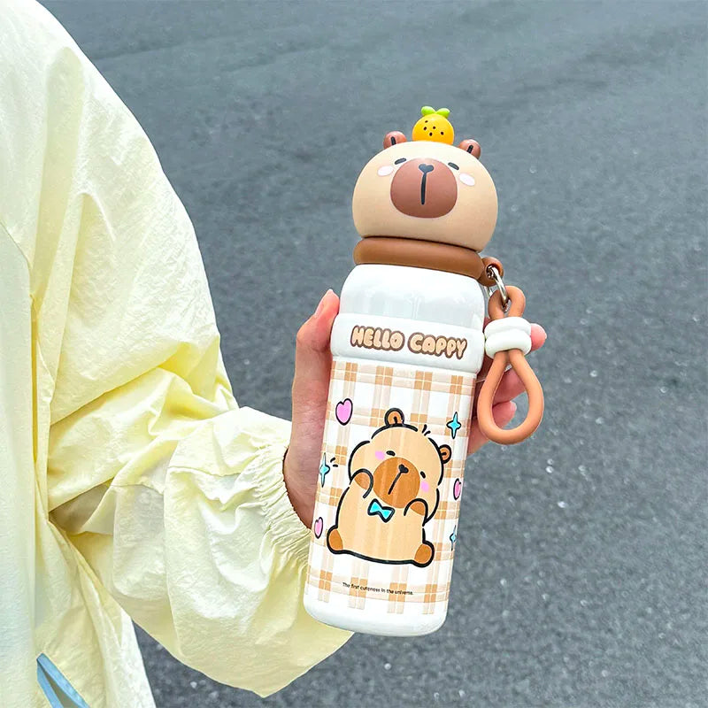 Cartoon bear-themed kawaii water bottle held by a person with a light-colored jacket.