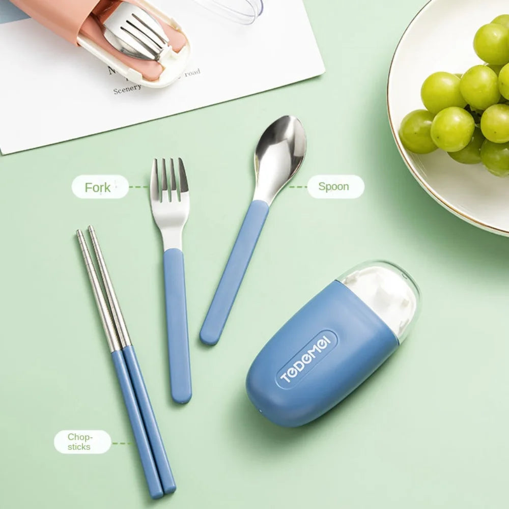 Set of silver kawaii utensils with blue handles on a green surface, including forks, a spoon, and chopsticks, with a container labeled 'Tedder'.