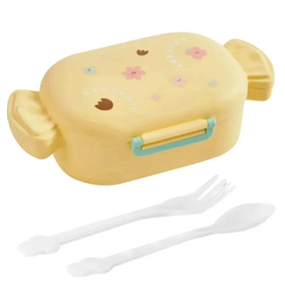 Yellow toy kawaii lunch box with floral patterns and cutlery on a white background