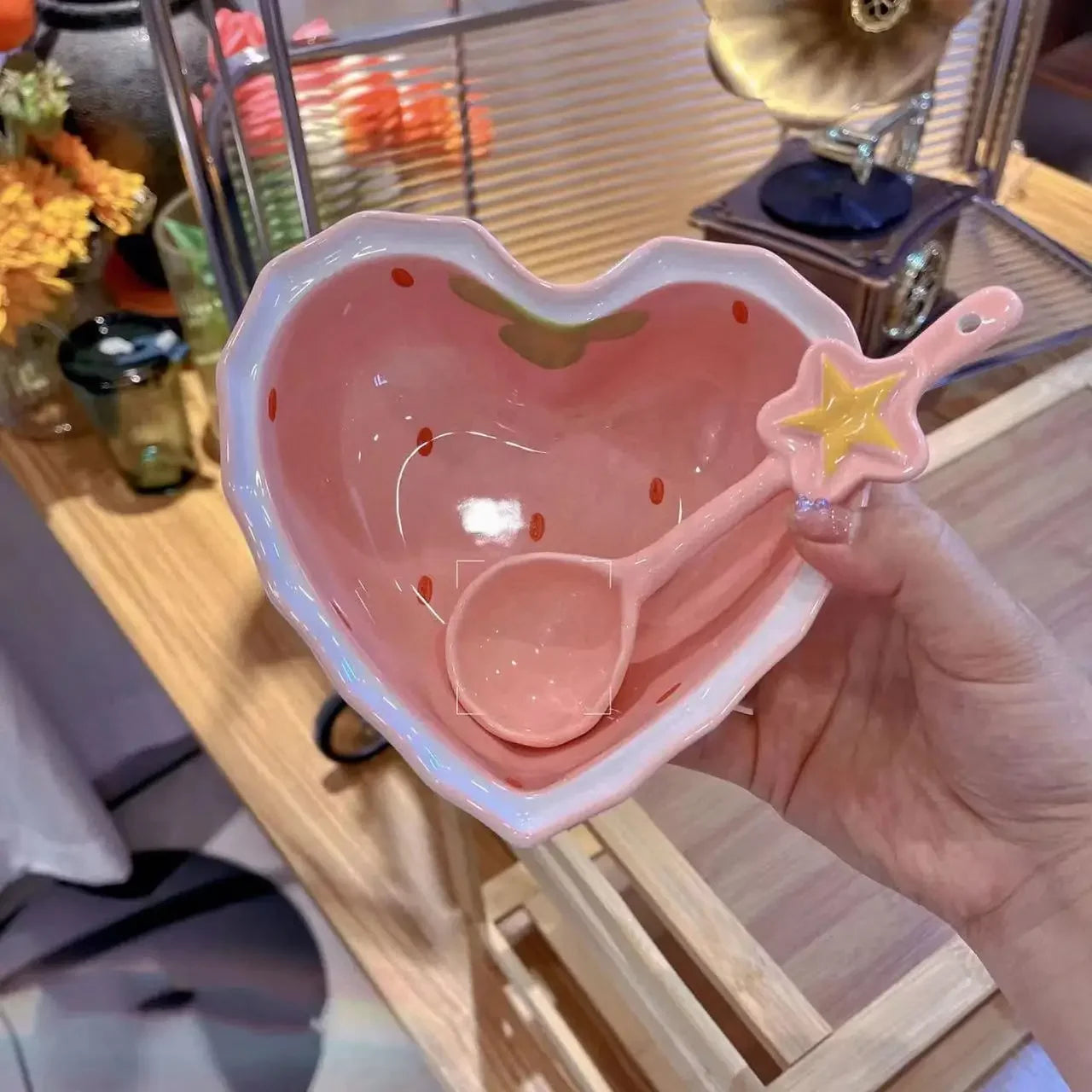 A strawberry heart shaped kawaii bowl being held by a person