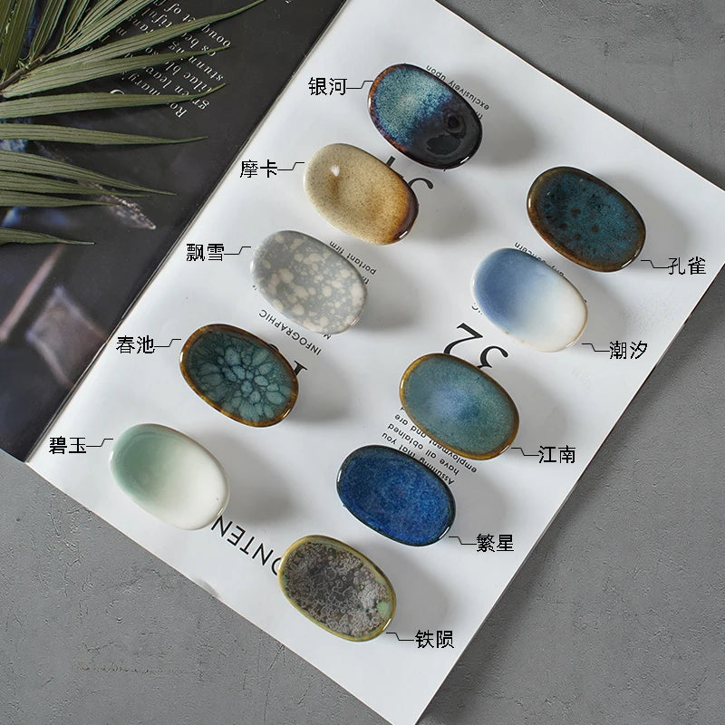 Set of ceramic kawaii chopstick holders with various glaze finishes on a white paper, labeled with names.