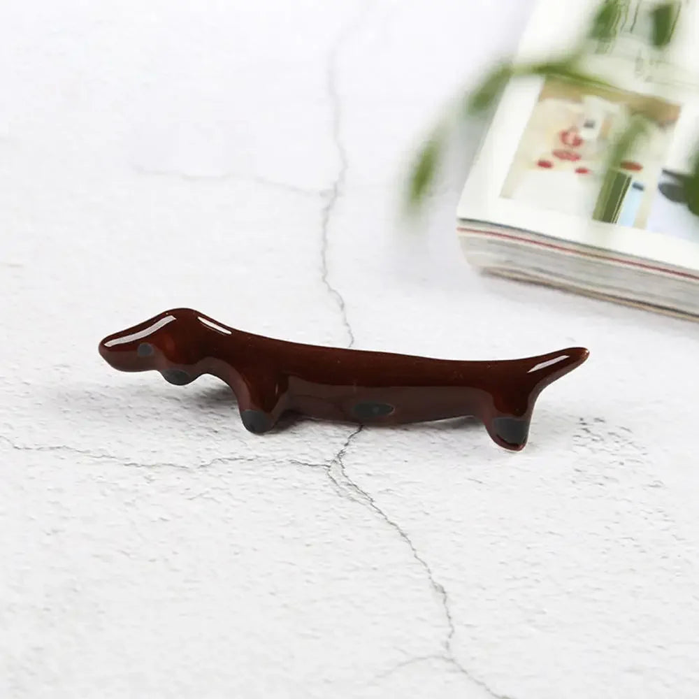 Brown ceramic dog-shaped kawaii chopstick holders on a light gray surface