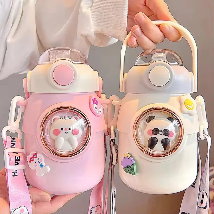Two cute kawaii water bottles with cartoon character designs held by a person.