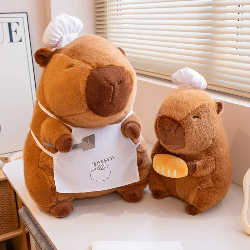 Two brown kawaii plush bears with chef hats and aprons on a white surface.