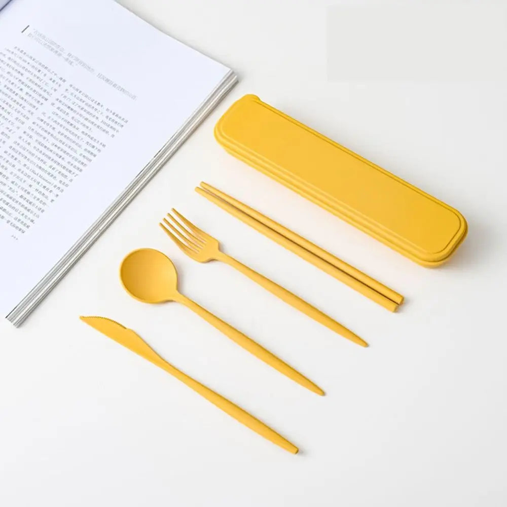 A set of yellow kawaii utensils with case on a table