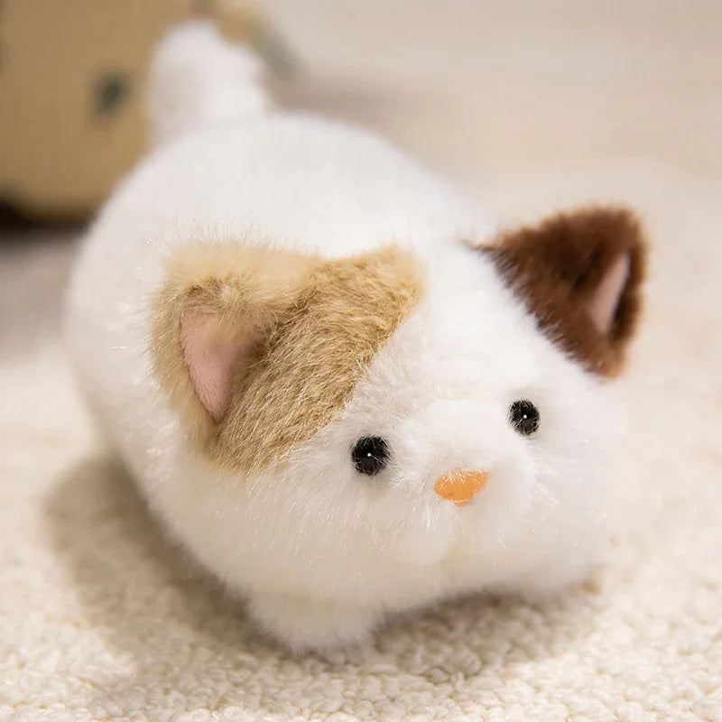 Kawaii plush toy resembling a cat with brown and beige ears on a soft surface
