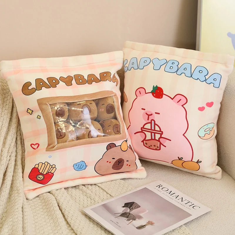 Two capybara-themed kawaii pillows on a couch with a magazine underneath.