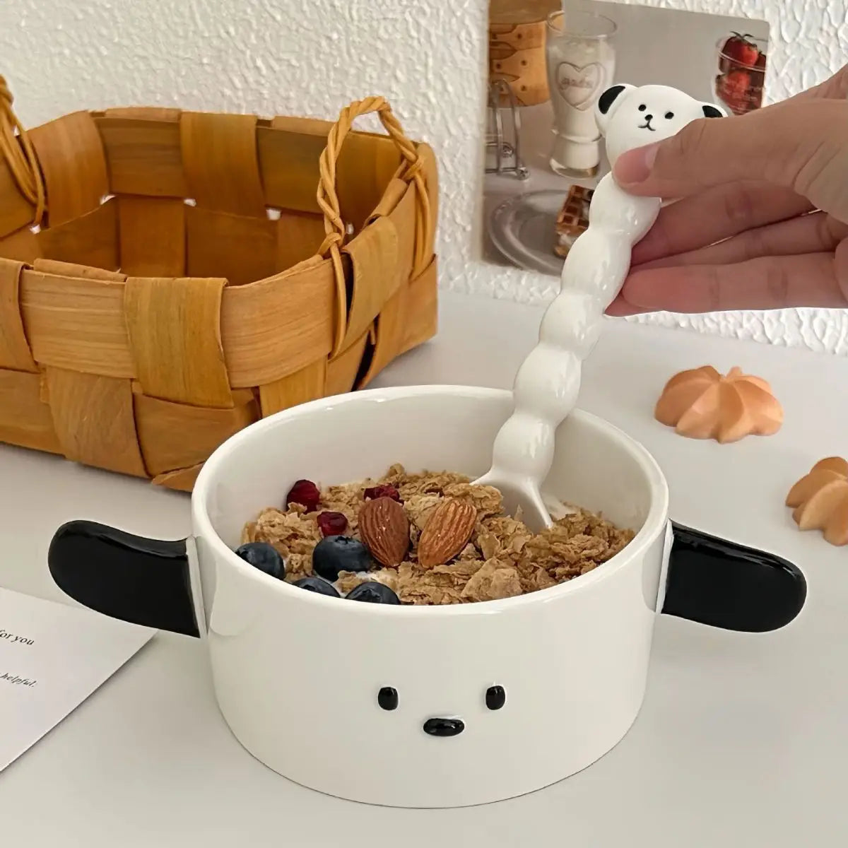 White dog-shaped kawaii ramen bowl with a hand using a white spoon to scoop cereal and fruit.