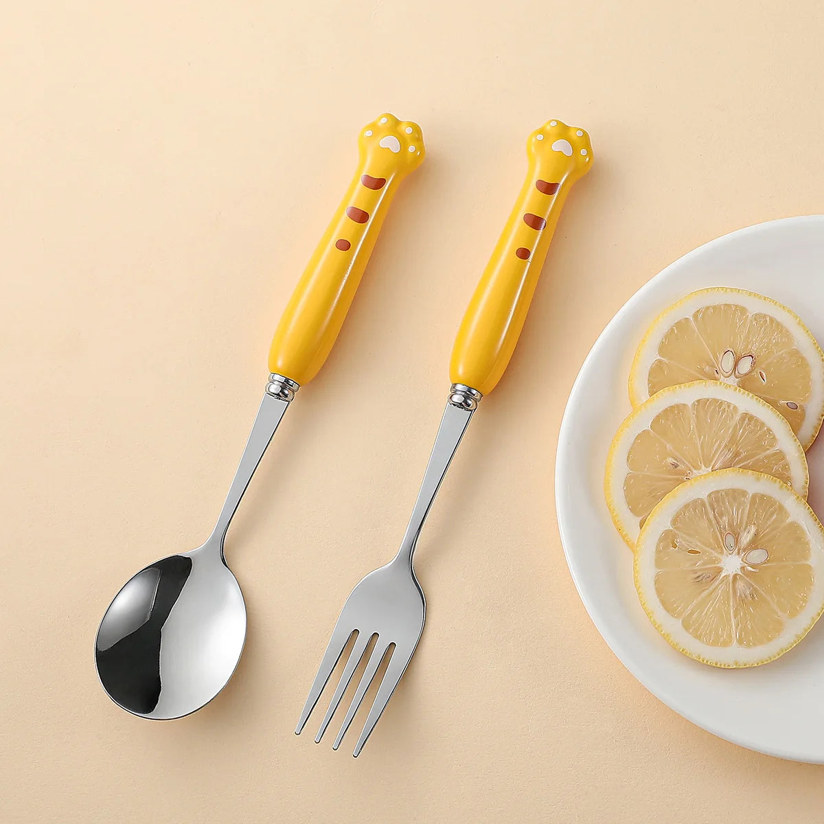 A set of yellow, paw shaped kawaii utensils on a table