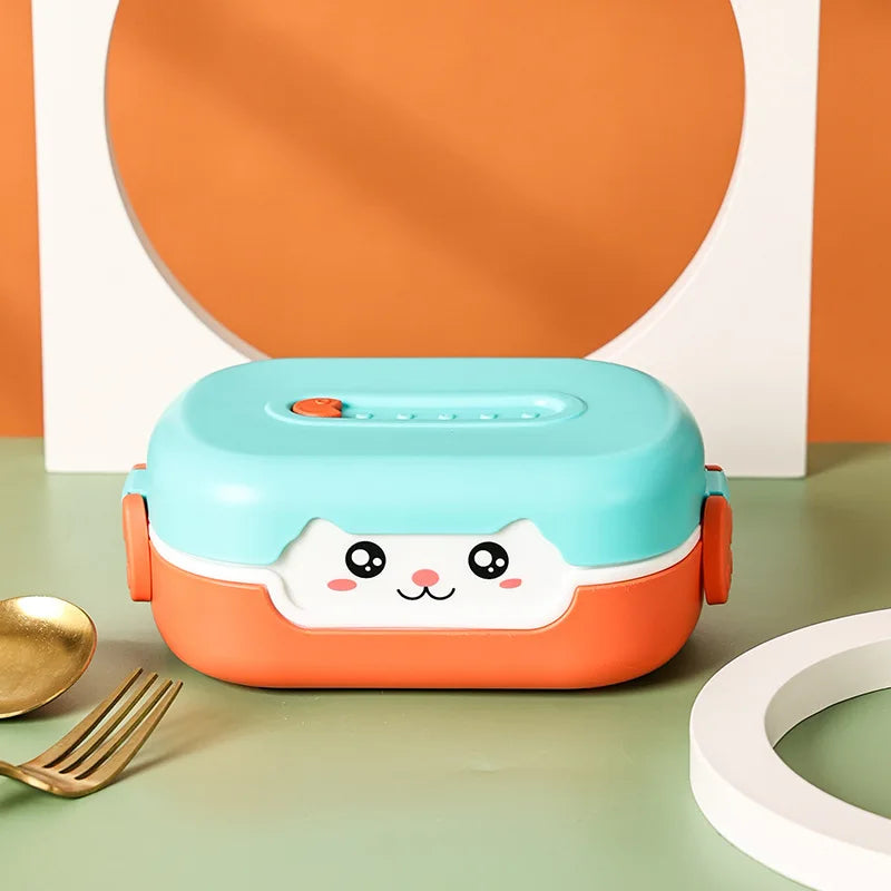Children's kawaii lunch box with a cute face design on a green surface with orange and white background