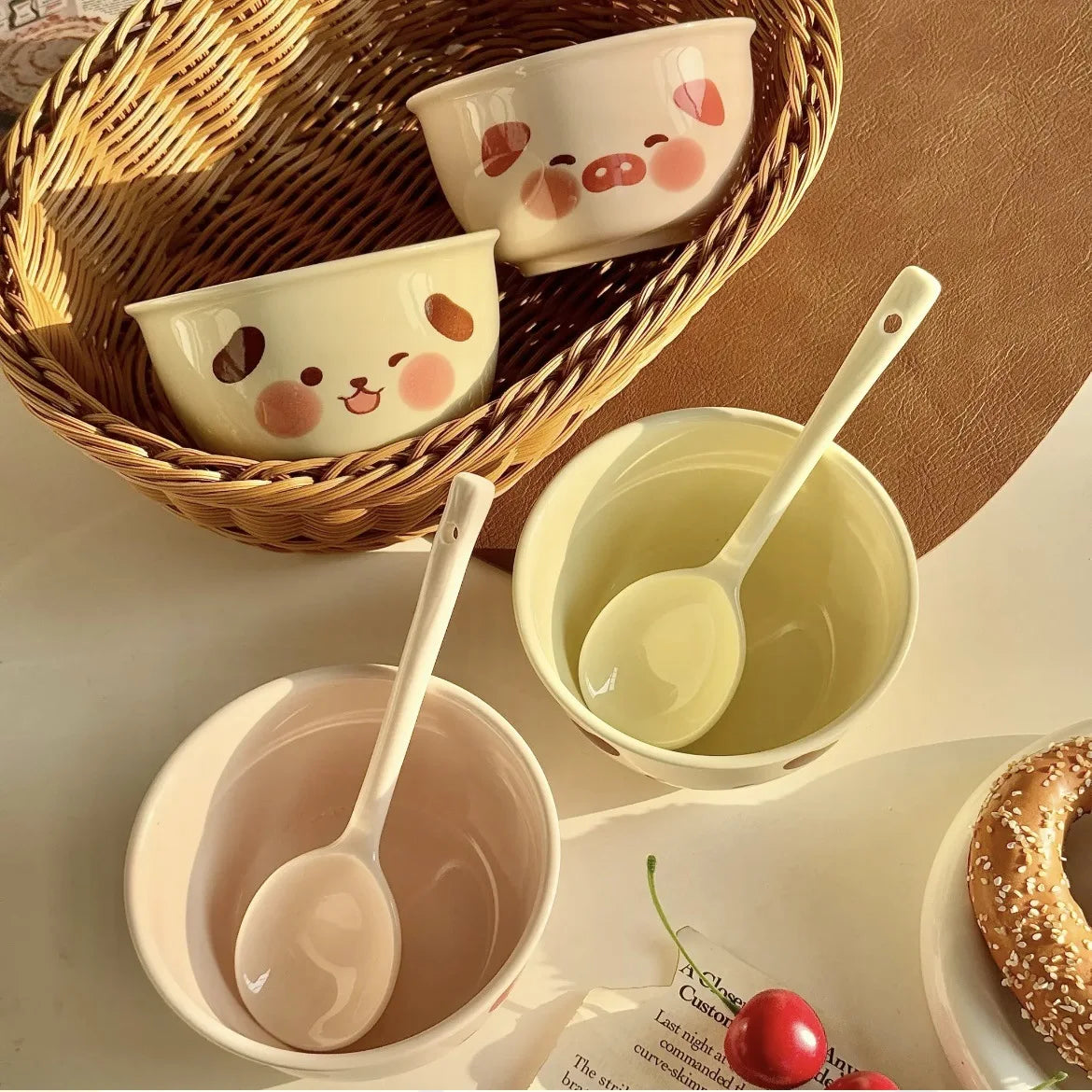 Ceramic kawaii ramen bowls with cartoon designs and spoons on a wooden surface