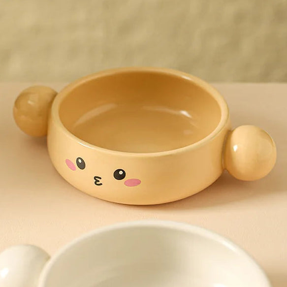 Yellow pet kawaii ramen bowl with a cute face design on a beige background