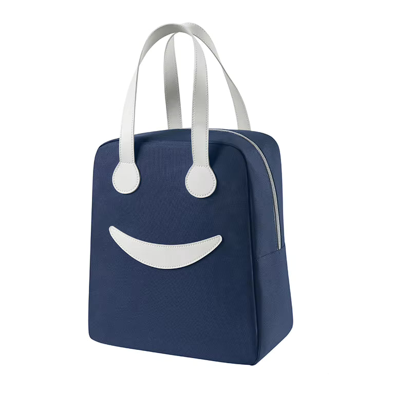 A navy blue insulated lunch bag with a white smiley face design on the front and white shoulder straps, shown on a plain white background.