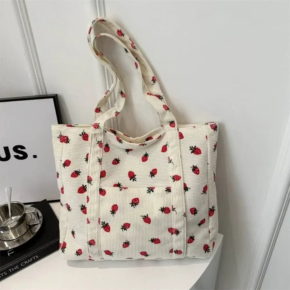 Tote bag with strawberry pattern on a white surface