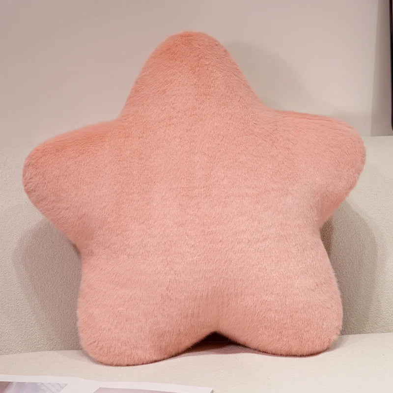 Pink star-shaped pillow on a light-colored couch