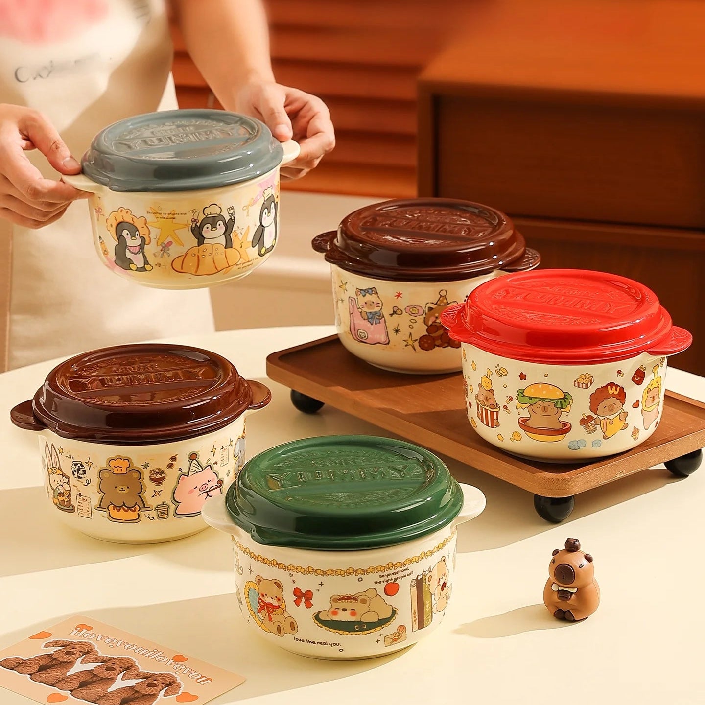 Set of ceramic kawaii ramen bowls with cartoon designs on a wooden surface.