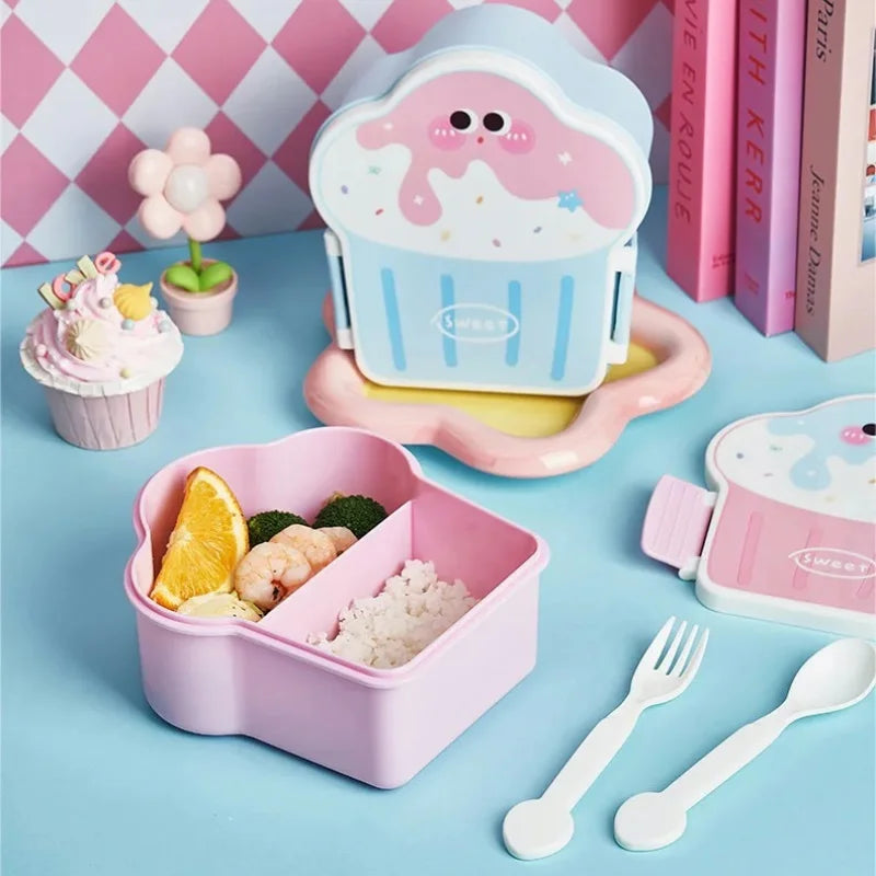 Pink kawaii bento box with food compartments on a blue surface with a checkered pink and white wall in the background.