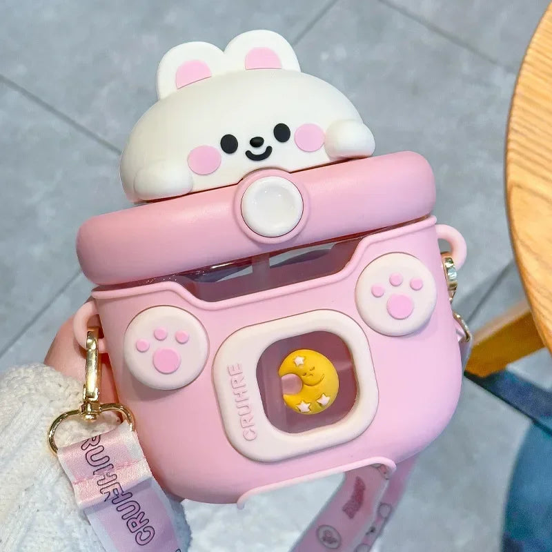 Pink cartoon-style kawaii water bottle with a bear design on a gray surface.