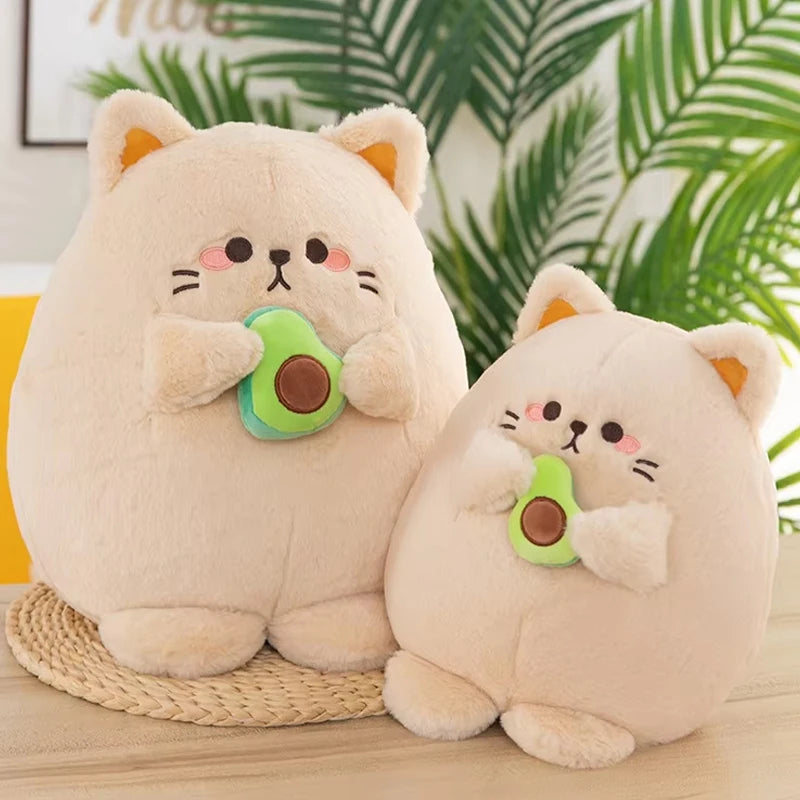 Two kawaii plush toys resembling cats with avocados on a wooden surface with a green leafy background.