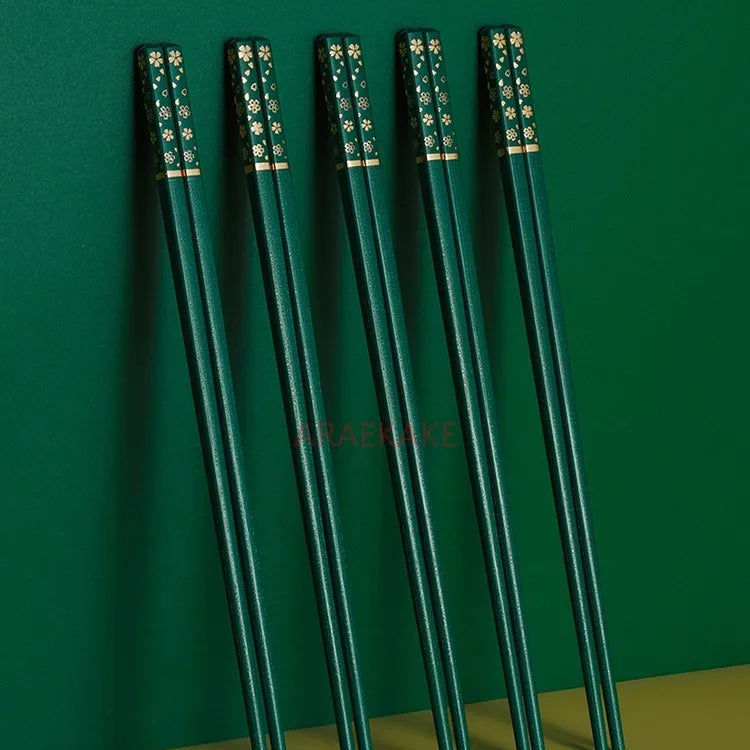 Set of green kawaii chopsticks with black handles on a green background