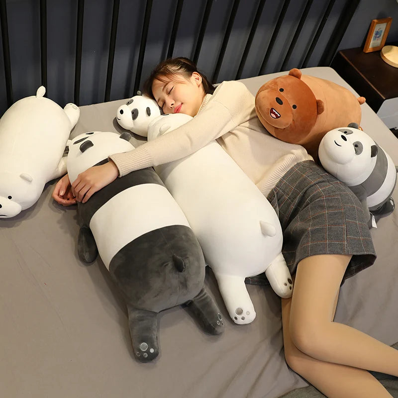Person lying on a bed with large kawaii plush animal toys, including panda and bear shapes.