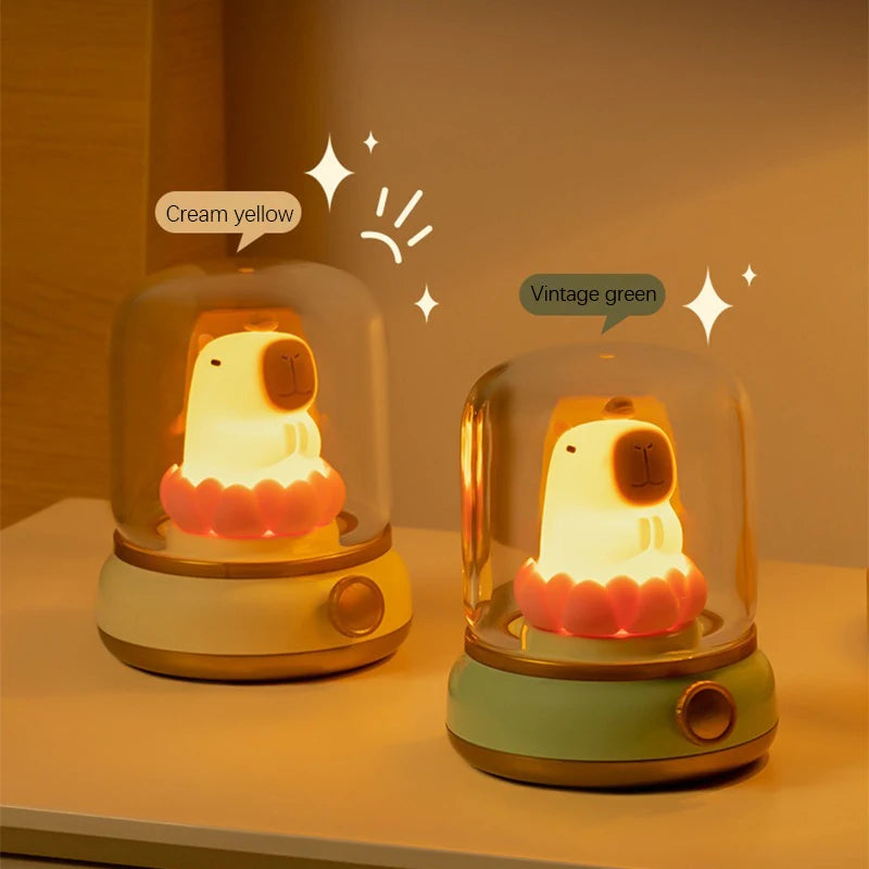 Two kawaii capybara night lights with 'Cream yellow' and 'Vintage green' labels on a wooden surface.