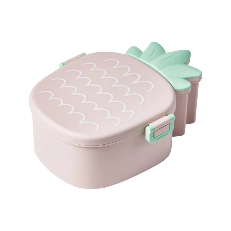Pink pineapple-shaped kawaii food container with a green lid on a white background