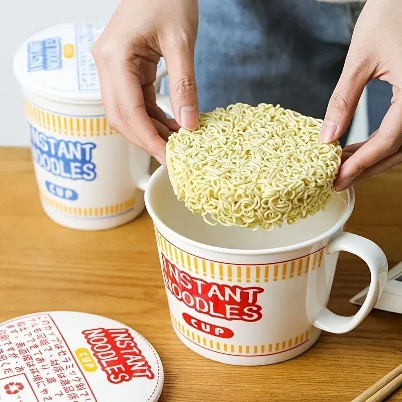 A hand placing noodles inside a kawaii ramen bowl