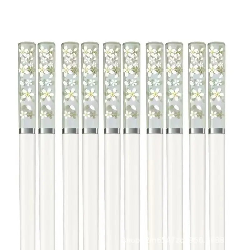 Set of white kawaii chopsticks with floral designs on the handles against a white background