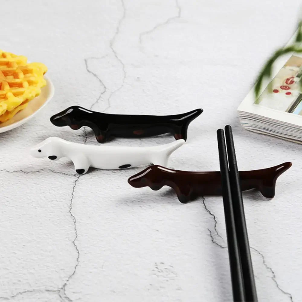 Dog-shaped kawaii chopstick holders on a marble surface with waffles and a magazine in the background.