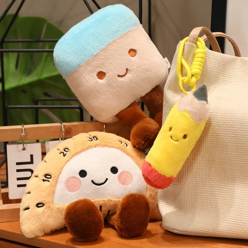 Kawaii plush toys resembling a character with a blue hat and a pencil-shaped keychain on a wooden surface.