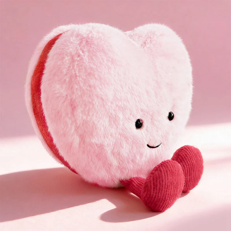 Heart-shaped kawaii plush toy with a smiling face on a pink background
