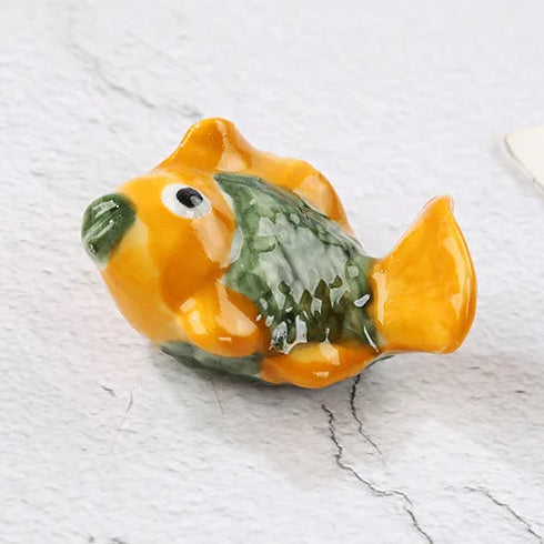 Small decorative fish kawaii chopstick holders on a textured surface with text indicating dimensions.
