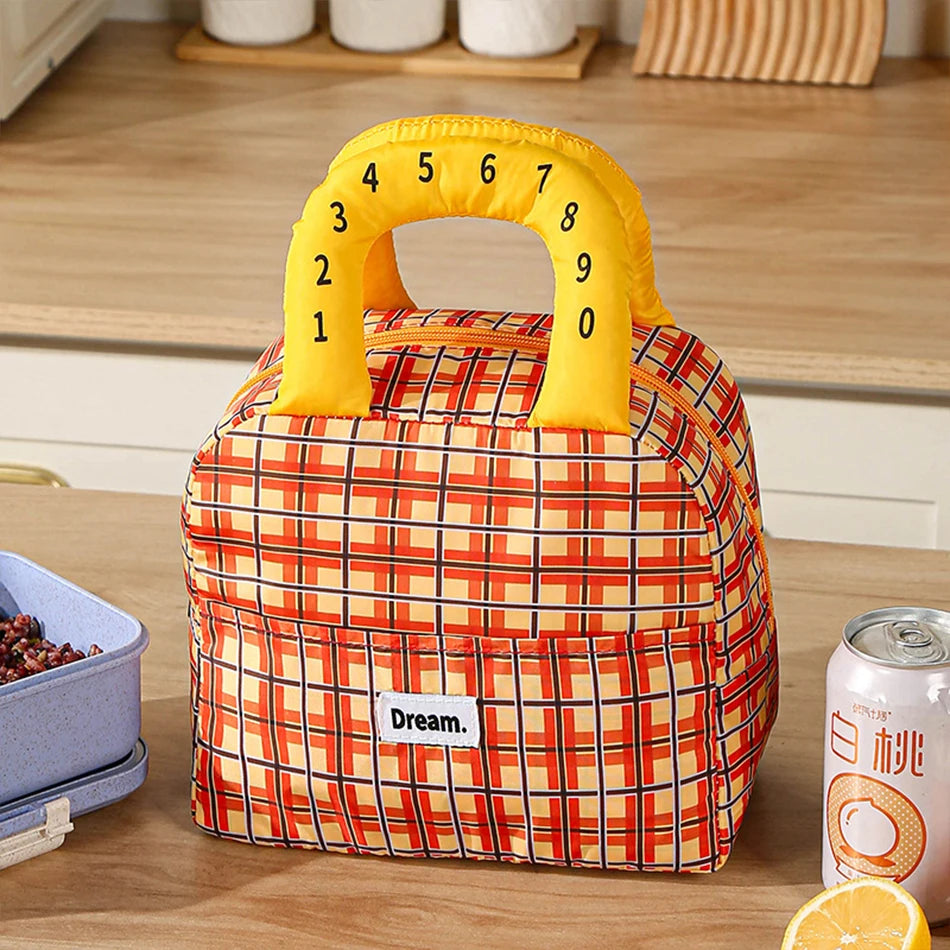 Plaid kawaii lunch bag with yellow number handle on a wooden surface