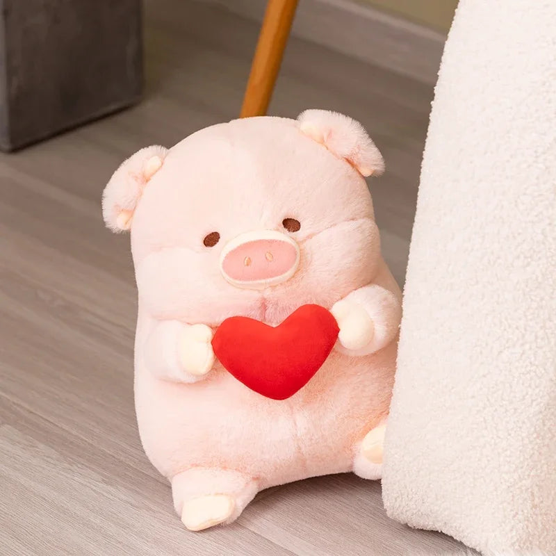 A pink kawaii pig plushy holding a love heart sitting on the floor