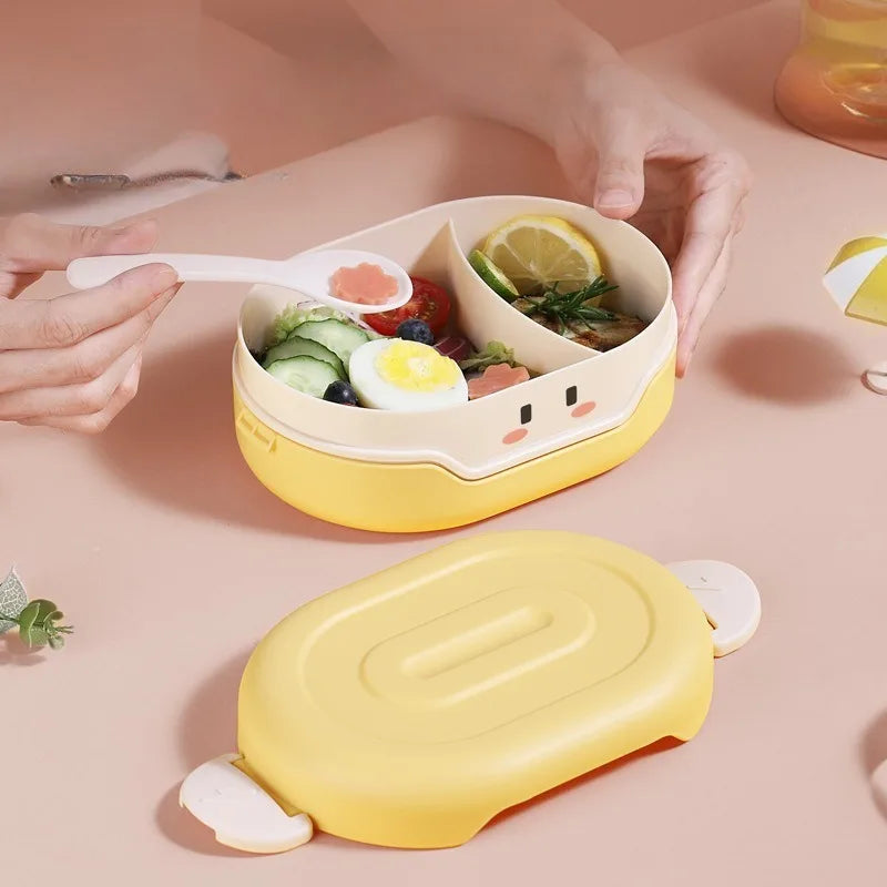 Yellow kawaii bento box with food compartments on a pink surface