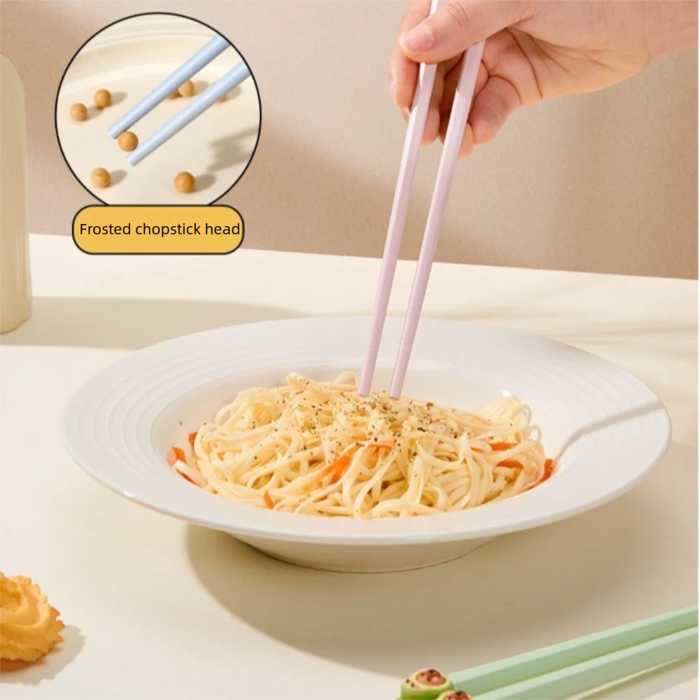 Person using pink kawaii chopsticks to pick up noodles from a white bowl on a beige background.