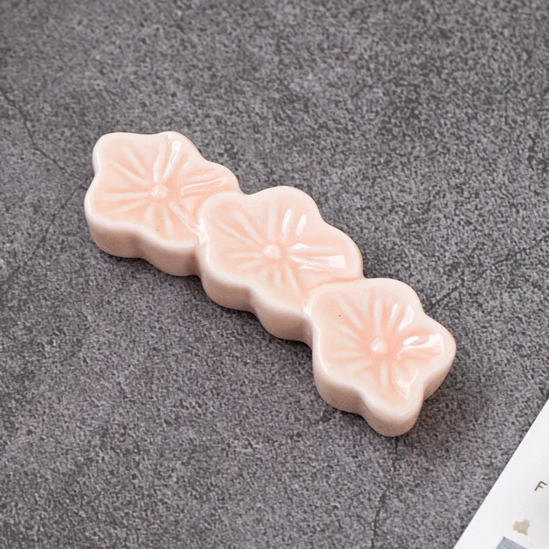 Pink floral-patterned kawaii chopstick holder on a gray surface