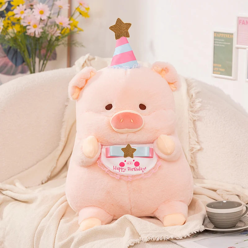 Pink kawaii plush pig toy with a birthday hat on a soft surface with flowers in the background